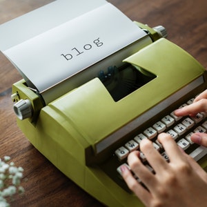 typewriter with paper that says blog