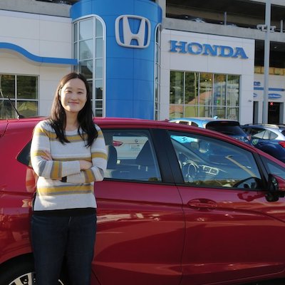 woman standing in front of a red car